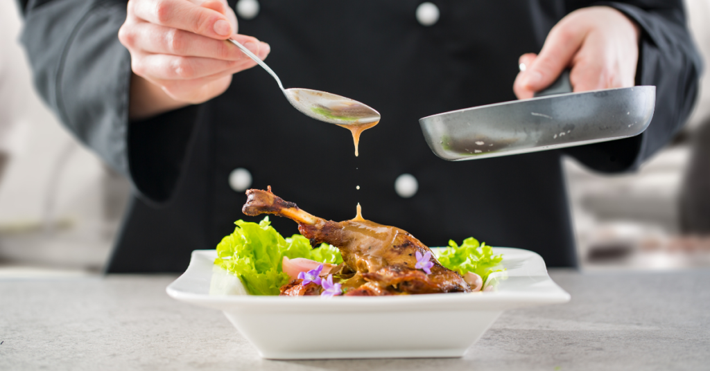 chef spooning gravy onto chicken