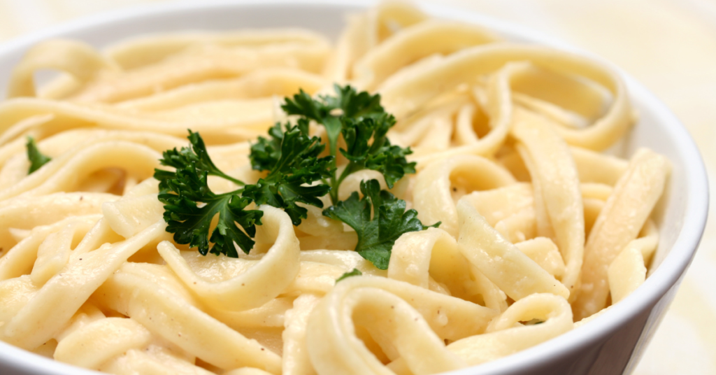 creamy pasta in a bowl with parsley garnish on top